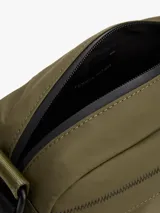 Cartera bandolera Tommy Hilfiger color verde militar, con correa ajustable negra, bolsillo frontal con cierre y logo de la marca en el frente.