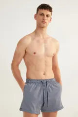 Short de baño azul marino con rayas verticales blancas, cintura elástica con cordón ajustable, bolsillos laterales y bolsillo trasero con cierre autoadherente.