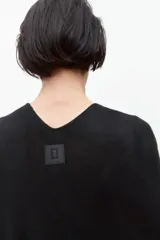 Capa negra tejida con volados.