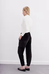 Pantalón babucha verde esmeralda de terciopelo con elástico en la botamanga, bolsillos plaqué en el frente con remaches metálicos y bolsillos cargo en las piernas.