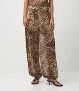 Pantalón ancho de tule con estampado de leopardo, cintura y puños elásticos. El conjunto se compone de un top sin mangas con cuello alto y un pantalón a juego con fajín anudado a la cintura.