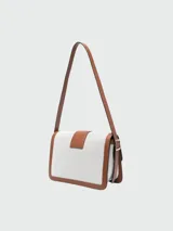 Bolso bandolera Longchamp modelo Box-Trot, tamaño mediano, color blanco con detalles en cuero marrón y herrajes dorados.