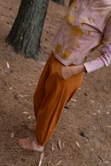 Pantalón tipo babucha color naranja, con cintura y puños elastizados, bolsillos delanteros y confeccionado en algodón.