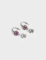 Set de dos pares de aros plateados: un par de argollas con dije de rosa roja y un par de aros tipo botón con forma de moño.