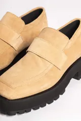 Mocasín de gamuza color verde oliva, con tira superior y suela track gruesa y negra.