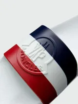 Sandalias de playa blancas con franjas azul marino, blanco y rojo en la tira superior. Logo de Moncler en relieve en la tira.