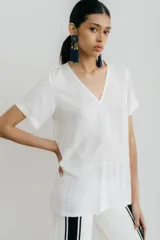 Remera blanca con corte horizontal y parte inferior negra. Cuello en V y mangas cortas.