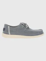 Alpargata negra con cordones elásticos y suela blanca con textura.