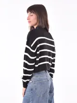 Polerón de tejido de punto color verde militar, con cuello alto y corte holgado.