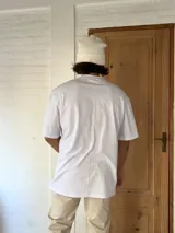 Remera blanca de algodón, corte amplio y mangas cortas.