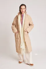 Campera acolchada larga color beige, con cierre frontal y bolsillos laterales.