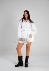 Conjunto blanco símil lino, compuesto por una camisa de manga globo y un short con cintura elastizada.