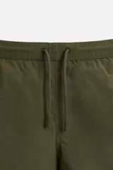 Short de baño negro de tejido técnico, con cintura elástica ajustable con cordón, bolsillos laterales y bolsillo trasero.