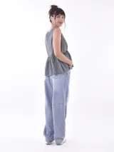 Blusa blanca sin mangas con escote en V y cierre frontal con botones.