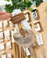 Collar con dije de nácar natural con forma irregular y cordón de cuero marrón con cuentas doradas.