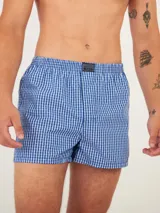 Bóxer de algodón blanco con estampado de flores pequeñas color celeste, con cintura elástica y logo de la marca en el centro.