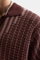 Polo relaxed fit de punto color borgoña con diseño geométrico en beige. Cuello solapa con abertura frontal, manga corta y acabados en rib.