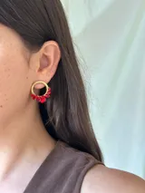 Aros tipo argolla plateados con cuentas de vidrio facetadas en tonos rosa y bordó.