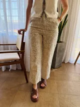Pantalón de lino color beige con bordado floral blanco, corte recto y cintura elastizada en la parte trasera.