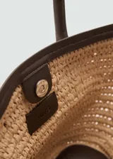 Bolso tipo shopper pequeño de fibra natural color beige, con doble asa corta de cuero sintético marrón y cierre de imán interior.