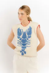Chaleco tejido color crema con diseño de langosta azul y detalles en rojo en cuello y ruedo.