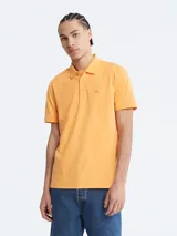 Chomba color naranja de manga corta, con cuello polo y tapeta de dos botones. Tiene el logo de Calvin Klein bordado en el pecho. Corte regular.