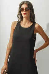 Vestido midi negro sin mangas, con cuello redondo y corte recto.
