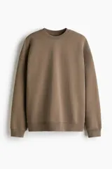 Buzo de tejido de algodón de peso medio, color marrón topo, con cuello redondo y hombros caídos. Presenta puños y bajo en punto acanalado.