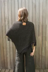 Poncho tejido en hilo de algodón con lurex color negro y dorado, con flecos en el ruedo.