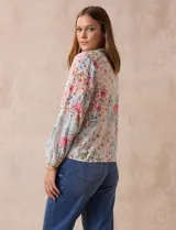 Blusa de gasa plisada estampada con flores azules, marca Floral & Ivy. Cuello a la base, escote en V y lazo de ajuste.