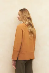 Polera de cuello alto, en color gris, con costuras tipo manga ranglan y diseño relajado.