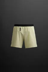 Shorts deportivos color gris oscuro confeccionados en tejido técnico ligero y elástico con forro interior, cintura elástica ajustable con cordón, bolsillos laterales, bolsillo de seguridad en espalda con cierre de cremallera, bajo con aberturas laterales y detalle de logo estampado en pernera.