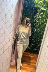 Conjunto deportivo color beige, compuesto por un buzo de cuello alto y corte holgado, y un pantalón jogger con cintura elástica.