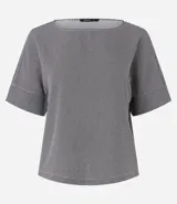 Blusa de crepé con estampado geométrico en blanco y negro, escote redondo y mangas cortas con detalle de doblez.