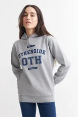 Hoodie gris con capucha y cordones ajustables. Estampado frontal con la palabra 'OTHERSIDE' y las siglas 'OTH' en azul marino.