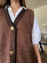 Chaleco tejido color marrón con detalles de lurex, escote en V, bordado con botones, terminaciones en crochet y bordados hechos a mano con lana merino.