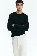 Remera negra de manga larga en punto waffle de mezcla de algodón de peso medio. Modelo con cuello redondo y ribete acanalado en cuello y puños.