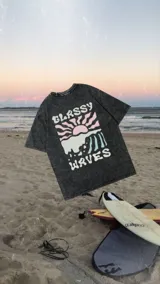 Remerón negro con efecto lavado y estampado en la espalda con un diseño de ondas, sol y la frase "Glassy Waves".
