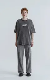 Remera negra de algodón con estampa sublimada en el frente con la palabra 'AMOR' y dibujos de manos, llaves, corazones y otros símbolos.