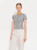 Top de jersey color gris con escote asimétrico, mangas irregulares y apliques de lentejuelas.