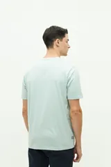 Remera verde agua de manga corta con estampado de dos fotografías en el frente.