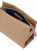 Cartera bandolera pequeña color beige con correa ajustable, confeccionada en poliéster reciclado y poliuretano. Presenta el logo TH metalizado en dorado en la parte delantera.