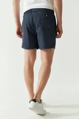 Short de baño liso color celeste, con cintura elástica ajustable con cordón, dos bolsillos laterales y uno trasero.