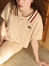 Chomba corta roja de algodón con cuello camisero con rayas celeste y negra. Logo bordado en el frente.