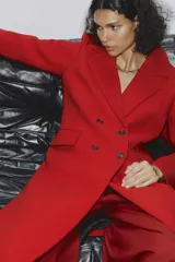 Abrigo rojo de lana con doble botonadura, cuello con solapa y bolsillos con solapa en la parte delantera.