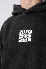 Buzo canguro negro con efecto gastado y estampa cuadrada con diseño abstracto en el pecho. Corte oversize con capucha y puños ajustados.