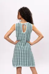 Vestido tejido a rayas verticales en tonos celeste y gris, sin mangas y largo a la rodilla. Incluye cinturón tejido con flecos.