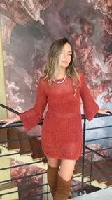 Vestido corto tejido en red color ladrillo, con mangas acampanadas y cuello redondo. Incluye forro desmontable de jersey.