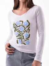 Remera blanca de manga larga con cuello redondo y estampado abstracto en tonos pastel.