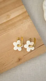 Par de aros tipo argolla de acero quirúrgico color dorado, con dije de flor blanca de acrílico.
